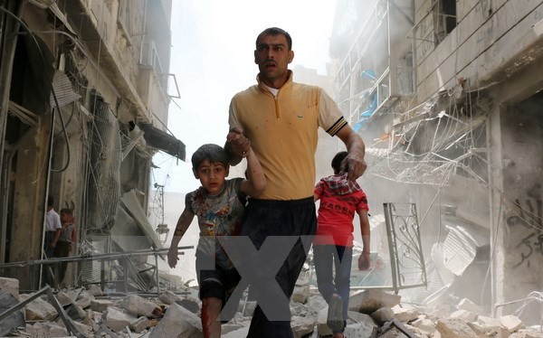 Người dân Syria sơ tán khỏi khu vực đổ nát sau một cuộc không kích ở Aleppo ngày 22/4. (Nguồn: AFP/TTXVN)