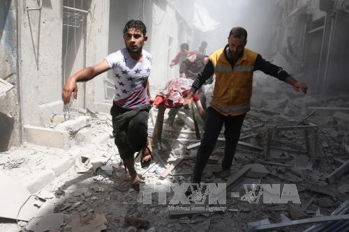 Chuyển thi thể một nạn nhân thiệt mạng trong cuộc không kích tại khu vực Al-Qatarji ở Aleppo. Ảnh: AFP/TTXVN