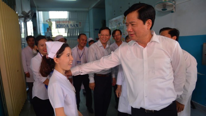 Bí thư Thành ủy TP.HCM Đinh La Thăng hỏi thăm một y tá đang công tác tại bệnh viện sáng 5-6 - Ảnh: QUANH ĐỊNH
