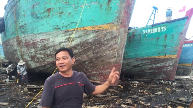 Ông Trà Văn Hoành bên tàu gỗ cỡ lớn đang bảo trì, sửa chữa định kỳ - Ảnh: MINH ĐỨC
