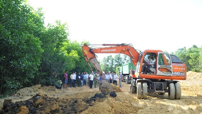 Lực lượng chức năng đã huy động 2 chiếc máy xúc đào bới 100 tấn chất thải của Formosa chôn lấp trái phép tại trang trại ở phường Kỳ Trinh đưa về nơi quy định. Ảnh: Xuân Đức.