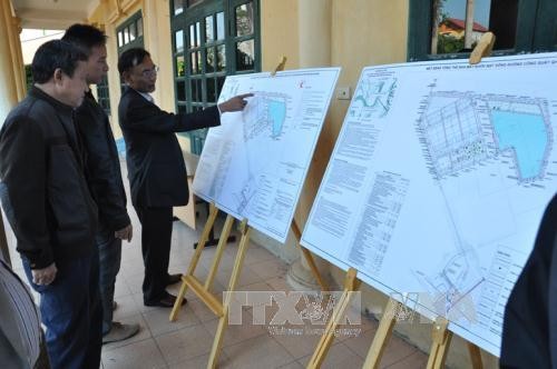 Người dân xã Phù Đổng, Trung Mầu (huyện Gia Lâm) xem bản quy hoạch nhà máy nước mặt sông Đuống. Ảnh: TTXVN