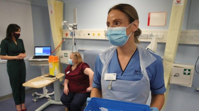 Một y tá chờ tiêm mũi đầu tiên trong số hai loại vắc xin Pfizer / BioNTech Covid-19 ở Edinburgh (Ảnh: Business Insider)