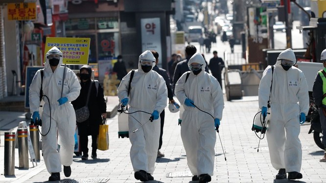 Dịch bệnh COVID-19 đã lan ra khắp thế giới và ngày càng nghiêm trọng. Ảnh: các nhân viên y tế Hàn Quốc phun thuốc khử trubngf trên đường phố (Ảnh: AP).