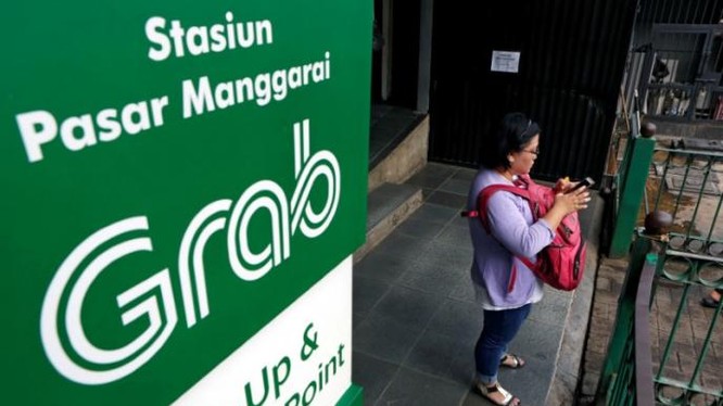 Một phụ nữ dùng ĐTDĐ gọi xe của hãng Grab tại Jakarta