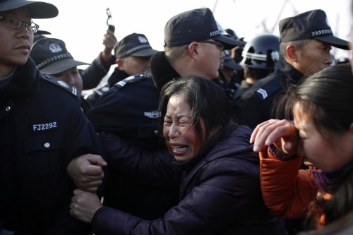 Thân nhân hành khách của tàu Ngôi sao phương Đông định phá hàng rào cảnh sát dọc sông Trường Giang. Ảnh: Reuters