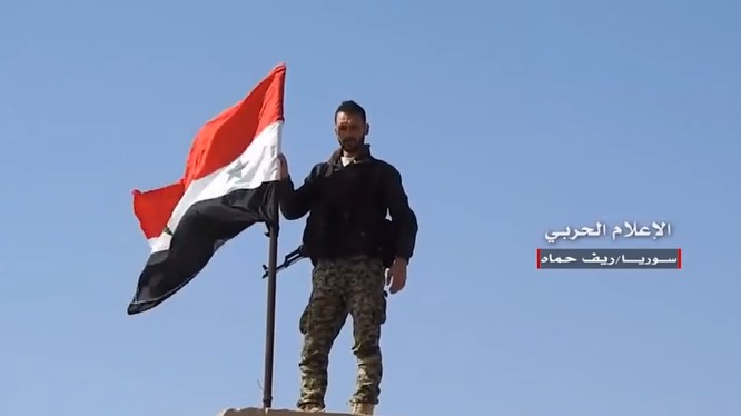 Một binh sĩ Syria thượng cờ trên thị trấn vừa giải phóng. Video truyền thông Hezboaah