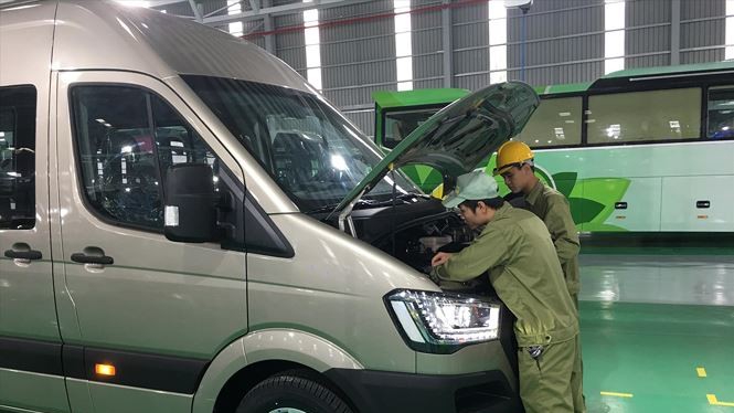 Các công nhân Thaco đang kiểm tra kỹ thuật xe buýt nhỏ Ảnh: Tuấn Nguyễn