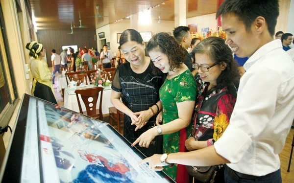 Du khách trải nghiệm ứng dụng du lịch thông minh tại Trung tâm thông tin du lịch Bát Tràng (Hà Nội)