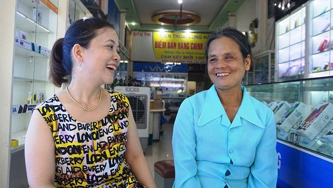 Chị chủ cửa hàng điện thoại và người phụ nữ đến mua thẻ cào (ảnh: báo Thanh Niên)