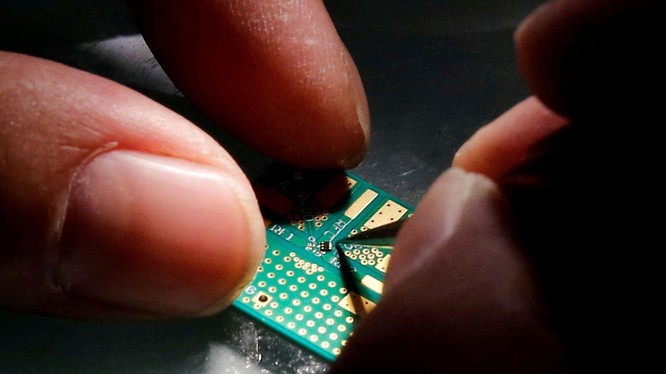 Một kỹ sư đặt chip bán dẫn lên bo mạch trong quá trình nghiên cứu thiết kế và phát triển sản phẩm bán dẫn tại Trung tâm Thanh Hoa Unigroup ở Bắc Kinh, Trung Quốc, ngày 29 tháng 2 năm 2016 (ảnh Reuters)