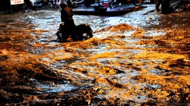 Người dân TP. HCM "bơi" trên đường khi triều cường - (Nguồn Internet)