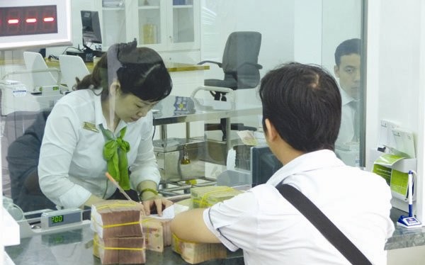 Giao dịch tại Vietcombank. Đây là một trong số ít ngân hàng có mức trả cổ tức bằng tiền ở mức 10-12%/năm. Ảnh: UYÊN VIỄN