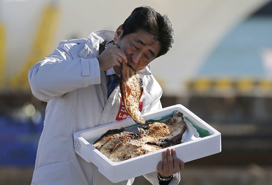 Ông Abe không ngần ngại ăn cá nướng tại tỉnh Fukushima. Ảnh: Reuters