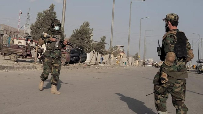 Chiến binh Taliban đứng gác một con đường dẫn tới sân bay Kabul (Ảnh: Reuters)
