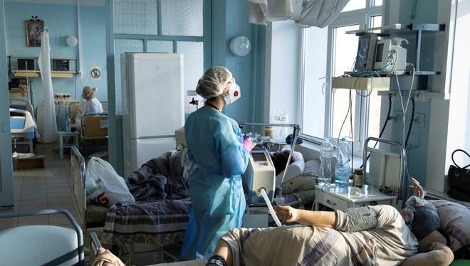 Nhân viên y tế điều trị cho bệnh nhân Covid-19 ở Ukraine hôm 26/10 (Ảnh: Reuters).