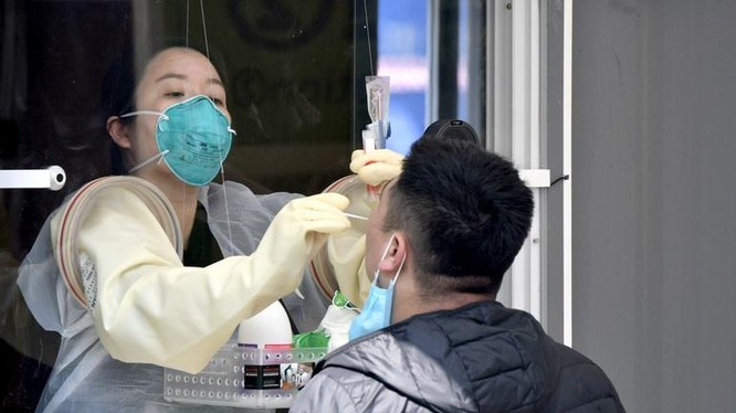 Một nhân viên y tế lấy mẫu xét nghiệm Covid-19 cho người dân ở Seoul (Ảnh: AFP).
