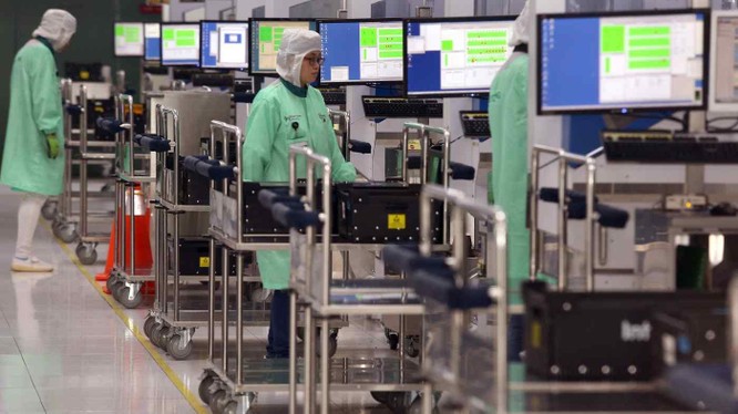 Công nhân trong một nhà máy ở Singapore nhập dữ liệu công việc vào các phương tiện tự động (Ảnh: AP)
