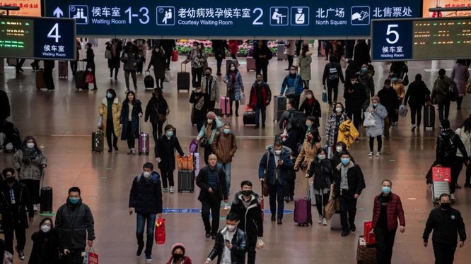 Người dân đeo mặt nạ khi đi du lịch vào dịp lễ năm mới tại nhà ga phía Tây Bắc Kinh, Trung Quốc. Ảnh: AFP