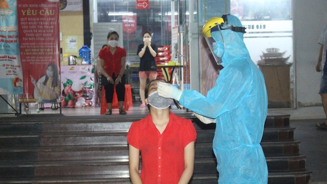 Nhân viên y tế lấy mẫu xét nghiệm COVID-19 cho người dân (Ảnh - TNTV) 