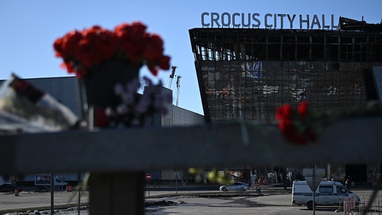 Hoa và đồ chơi được đặt bên lề đường trước Tòa thị chính Crocus, sau vụ tấn công khủng bố gần Moscow (Ảnh: Sputnik)