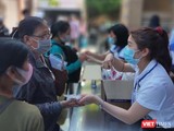 Hướng dẫn người dân khai báo y tế và sát khuẩn, sàng lọc COVID-19 ngay tại khu vực đón tiếp của BV Đại học Y Dược TP.HCM (Ảnh: Hoà Bình)