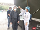 Nhân viên y tế kiểm tra thân nhiệt cho người dân (Ảnh: Minh Thuý)
