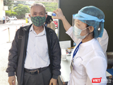 Nhân viên y tế kiểm tra nhiệt độ cho người dân (Ảnh - Minh Thuý)