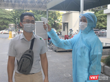 Nhân viên y tế kiểm tra nhiệt độ của người dân trước khi vào bệnh viện (Ảnh - Minh Thuý)