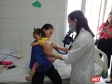 Bác sĩ khám cho trẻ nhỏ mắc sởi