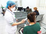 Bác sĩ đo nhiệt độ cho bệnh nhân tại Bệnh viện Bạch Mai. Ảnh: Minh Thúy