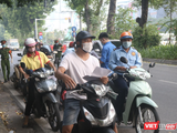 Người dân xếp hàng chờ kiểm tra giấy đi đường (Ảnh - Minh Thuý)