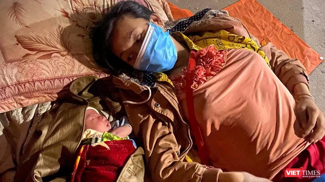 Mẹ con bé trai 10 ngày tuổi nằm nghỉ bên hiên nhà trong chuyền hành trình hơn 1.400km từ TP HCM về quê đi ngang qua Đà Nẵng (ảnh Minh Việt)