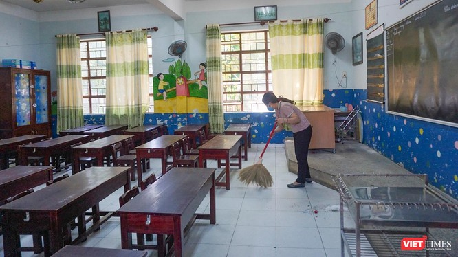 Nhân viên dọn dẹp phòng học để đón học sinh trở lại lớp