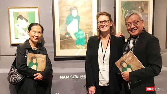 Nhà nghiên cứu Ngô Kim Khôi (bên phải) cạnh bức tranh lụa "Thiếu nữ cầm quạt" của họa sĩ Nam Sơn trưng bày tại Pháp 