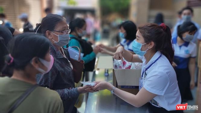 Hướng dẫn người dân khai báo y tế và sát khuẩn, sàng lọc COVID-19 ngay tại khu vực đón tiếp của BV Đại học Y Dược TP.HCM (Ảnh: Hoà Bình) 