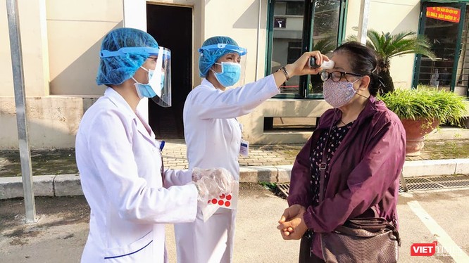 Nhân viên y tế đo nhiệt độ cho người dân để phòng COVID-19 tại Bệnh viện Hữu Nghị. Ảnh: Minh Thúy 