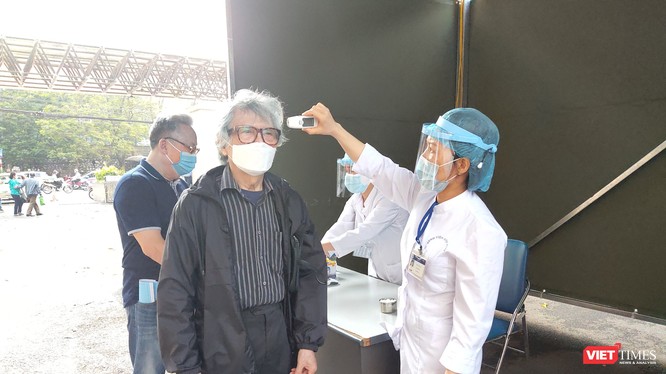 Nhân viên y tế đo thân nhiệt cho người dân tại Bệnh viện Hữu Nghị. Ảnh: Minh Thúy
