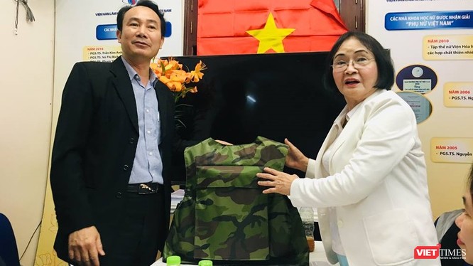 Đại diện Z117 và PGS.TS. Nguyễn Thị Hòe giới thiệu chiếc áo chống đạn sẽ được sử dụng sơn chống đạn và sơn chống cháy. (Ảnh: T.H)