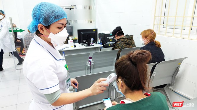 Bác sĩ kiểm tra thân nhiệt cho bệnh nhân tại Bệnh viện Bạch Mai. Ảnh: Minh Thúy 