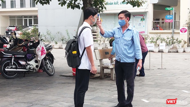 Học sinh được đo nhiệt độ trước khi vào lớp. Ảnh: Minh Thúy 