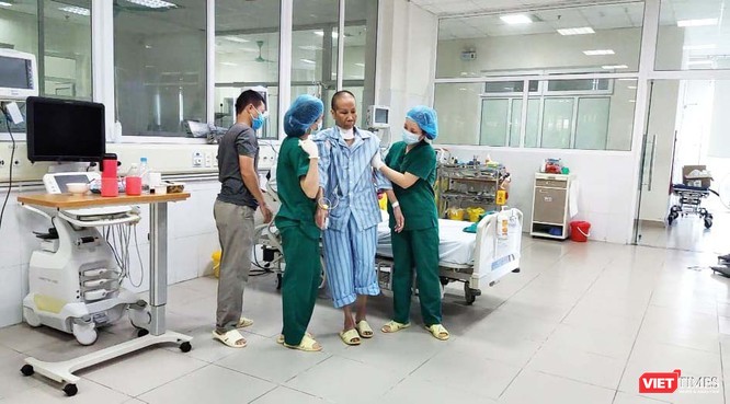 Bệnh nhân 19 được các bác sĩ dìu để tập đi lại ình thường. Ảnh: Minh Thúy 