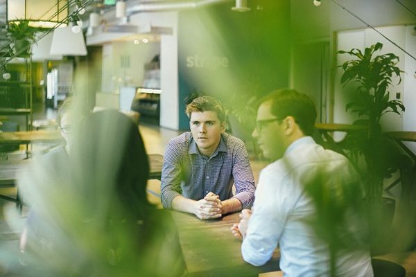 John đang làm việc với nhân viên tại trụ sở