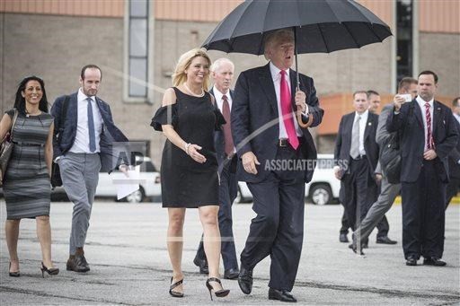Ông Trump che ô để bảo vệ mái tóc của mình. (Nguồn: AP).