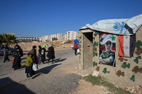 Người dân đi bộ trên một tuyến phố thuộc Aleppo.