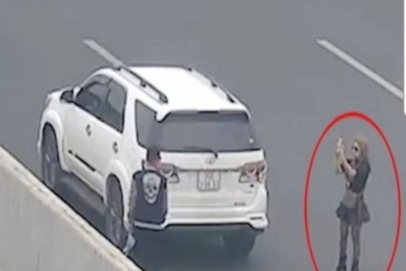 Người phụ nữ chụp ảnh cho bạn ngay trên đường cao tốc, bị camera ghi lại - Ảnh cắt từ camera Cục Cảnh sát giao thông