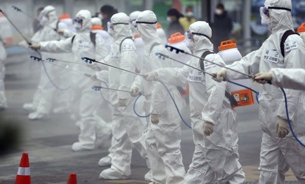 Binh sĩ Hàn Quốc mặc đồ bảo hộ phun thuốc khử trùng ở Daegu. Ảnh: AP.