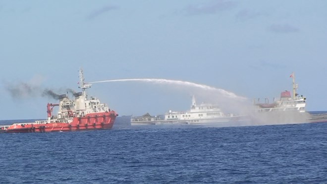Tàu kéo Trung Quốc (màu đỏ) đang dùng vòi rồng tấn công tàu cảnh sát biển Việt Nam, tháng 5/2014.