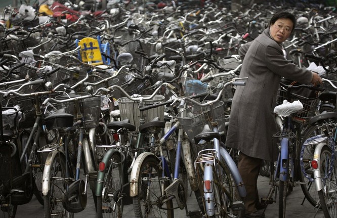 Một phụ nữ lấy xe đạp ở bãi xe ở Bắc Kinh