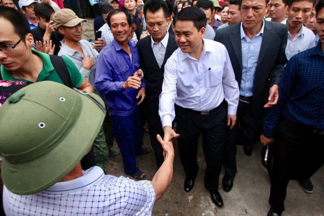 Ông Nguyễn Đức Chung, chủ tịch UBND TP Hà Nội, bắt tay người dân sau khi kết thúc buổi đối thoại với người dân tại thôn Hoành - Ảnh: NGUYỄN KHÁNH